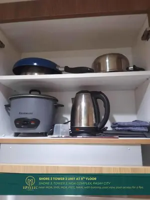 a shelf with pots and pans on top at Shore 3 Residences Spacious & Spotless 1BR unit near airport MOA SMX in Manila