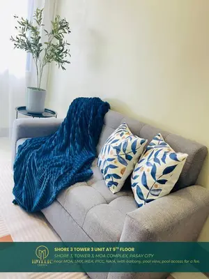 a blue blanket sitting on a couch with pillows at Shore 3 Residences Spacious & Spotless 1BR unit near airport MOA SMX in Manila