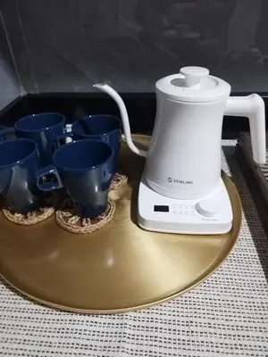 a blender sitting on a gold plate with blue cups at Larsie's Place in Manila