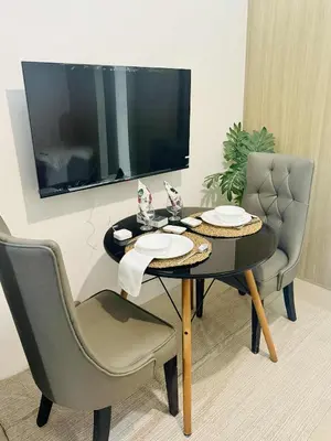 a dining room table with two chairs and a television at Larsie's Place in Manila