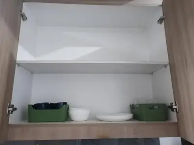 a shelf with bowls and plates on it at Larsie's Place in Manila