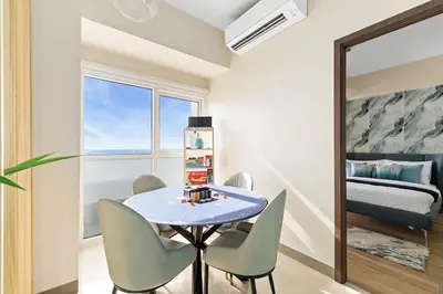 a dining room with a table and chairs and a bedroom at Bayshoreluxe in Manila