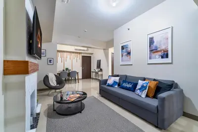 a living room with a blue couch and a table at Bayshoreluxe in Manila