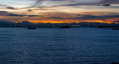 a group of boats in the water at sunset at Bayshoreluxe in Manila