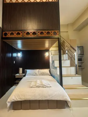 a bedroom with a bunk bed with a staircase at Comin'Joy Condotel at ONE PALM TREE VILLAS in Manila