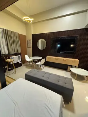 a living room with a couch and a flat screen tv at Comin'Joy Condotel at ONE PALM TREE VILLAS in Manila