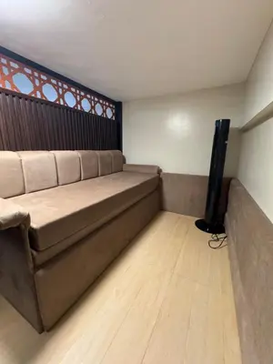 a living room with a couch and a flat screen tv at Comin'Joy Condotel at ONE PALM TREE VILLAS in Manila