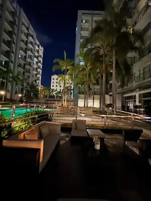 a courtyard with couches and palm trees at night at Comin'Joy Condotel at ONE PALM TREE VILLAS in Manila