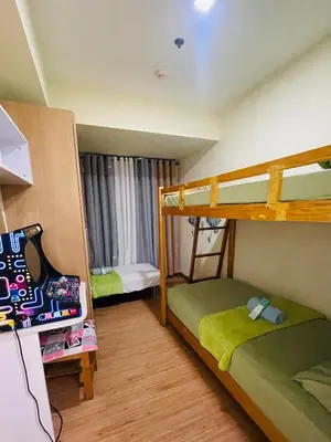 a bedroom with two bunk beds and a window at Rhome Staycation by Azure St Tropez Tower Beach View Condo Unit in Manila