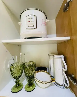 a kitchen shelf with two wine glasses and a toaster at Rhome Staycation by Azure St Tropez Tower Beach View Condo Unit in Manila