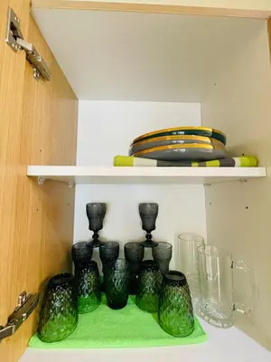 a bunch of green glass vases sitting on a shelf at Rhome Staycation by Azure St Tropez Tower Beach View Condo Unit in Manila