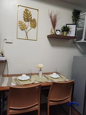 a dining room table with two plates and chairs at CHIC 1 BR in Air Residences in Manila