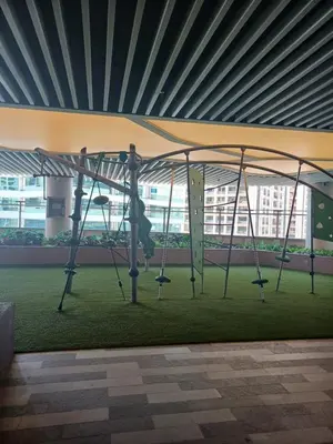 a swing set in a building with a green grass at CHIC 1 BR in Air Residences in Manila