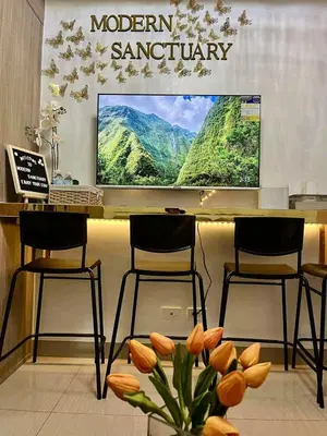 a display with two stools and a monitor in a store at Modern Sanctuary Near - MOA in Manila