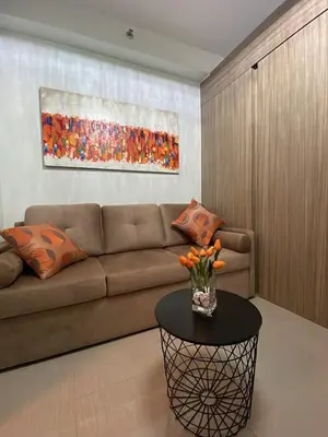 a living room with a couch and a table at Modern Sanctuary Near - MOA in Manila