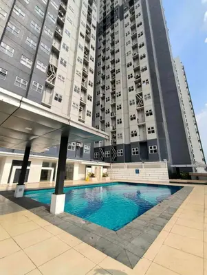 a large building with a swimming pool in front of a building at Gen coZy Condo Stay by Victoria de Manila Tower in Manila