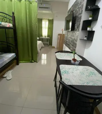 a room with a bed and a table and chairs at Gen coZy Condo Stay by Victoria de Manila Tower in Manila