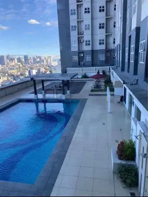 a swimming pool on the roof of a building at Gen coZy Condo Stay by Victoria de Manila Tower in Manila