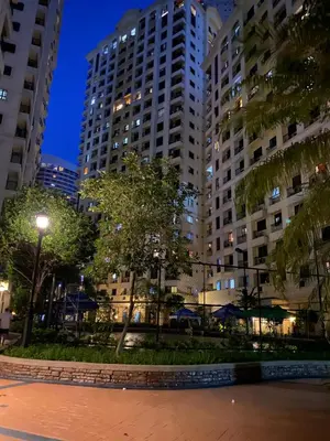 a park in a city at night with tall buildings at BGC Condominium Near St Luke Fort Bonifacio Taguig in Manila