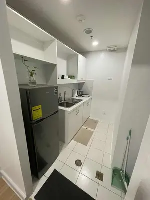 a small kitchen with a sink and a refrigerator at BGC Condominium Near St Luke Fort Bonifacio Taguig in Manila