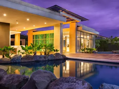 a house with a swimming pool in front of it at Condo Free Pool Fast Wi-fi near BGC, C5 in Manila