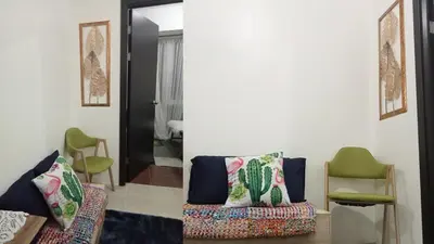 a living room with a couch and a chair at Condo Free Pool Fast Wi-fi near BGC, C5 in Manila