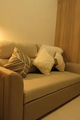 two pillows sitting on a couch in a living room at The Metro Suite - 1BR Condo 36F with City View in Manila