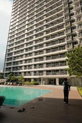 a person standing in front of a large building at The Metro Suite - 1BR Condo 36F with City View in Manila