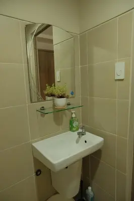 a bathroom with a sink and a mirror at The Metro Suite - 1BR Condo 36F with City View in Manila