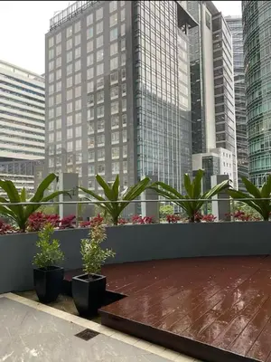 a balcony with potted plants and tall buildings at Avant at the Fort BGC with King Bed and Motorized Curtains & 65 in TV in Manila