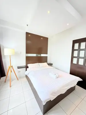 a bedroom with a large bed with a wooden headboard at Manila Korea Town Seaview and City View Staycation in Manila