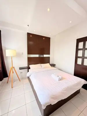 a bedroom with a large bed with a wooden headboard at Manila Korea Town Seaview and City View Staycation in Manila