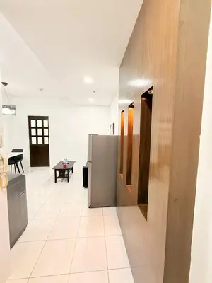 a kitchen with a stainless steel refrigerator and a table at Manila Korea Town Seaview and City View Staycation in Manila