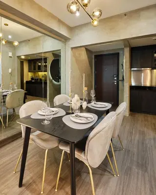 a dining room with a black table and white chairs at Luxury Condo in the heart of BGC in Manila
