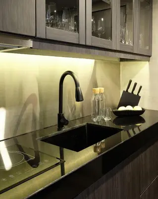 a kitchen with a black sink and a counter at Luxury Condo in the heart of BGC in Manila