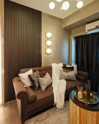 a living room with a brown couch and a table at Luxury Condo in the heart of BGC in Manila