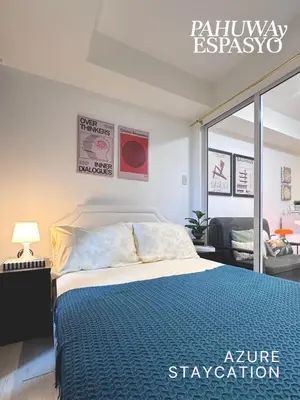 a bedroom with a bed with a blue comforter at Azure Bahamas by Pahuway Espasyo in Manila