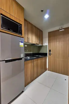 a kitchen with a stainless steel refrigerator and wooden cabinets at Minimalist Stay Mall of Asia WiFi, Netflix, Self Checkin in Manila