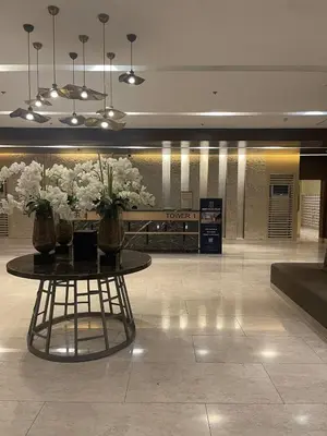 a lobby with a table with flowers on it at Minimalist Stay Mall of Asia WiFi, Netflix, Self Checkin in Manila