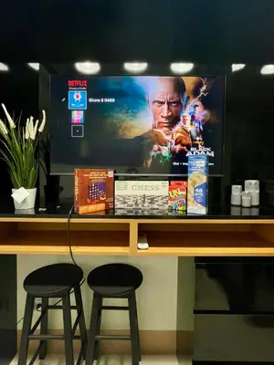 a flat screen tv sitting on a table with two stools at Minimalist Stay Mall of Asia WiFi, Netflix, Self Checkin in Manila