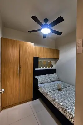 a bedroom with a bed and a ceiling fan at Minimalist Stay Mall of Asia WiFi, Netflix, Self Checkin in Manila