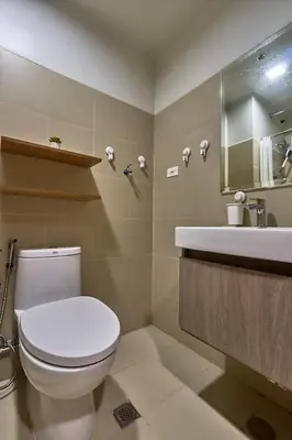 a bathroom with a white toilet and a sink at Minimalist Stay Mall of Asia WiFi, Netflix, Self Checkin in Manila