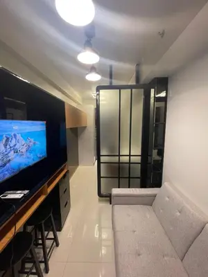 a living room with a couch and a flat screen tv at Minimalist Stay Mall of Asia WiFi, Netflix, Self Checkin in Manila