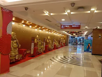 a hallway of a shopping mall with gold statues at Pristine Hotel in Manila