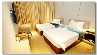 a hotel room with two beds and a television at Pristine Hotel in Manila