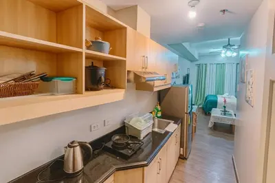 a kitchen with wooden cabinets and a counter top at La Suitez 1421 l Sky Studio l 360 City l Sea View in Manila