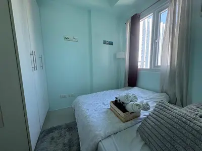 a bedroom with a bed with a stuffed animal on it at Stylish Makati 2BR Condo with KTV and Awesome Pools! in Manila