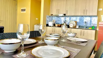 a table with plates and wine glasses on it at SMDC BREEZE RESIDENCES Pasay near AIRPORT PICC CCP WORLD TRADE CENTER MOA AND STARCITY in Manila
