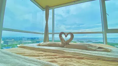 two swans laying on a bed in front of a window at SMDC BREEZE RESIDENCES Pasay near AIRPORT PICC CCP WORLD TRADE CENTER MOA AND STARCITY in Manila