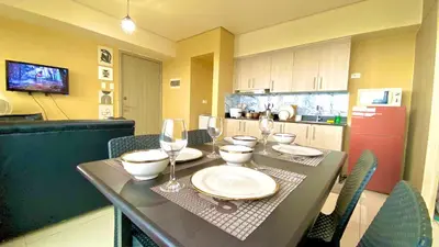 a kitchen with a table with plates and wine glasses at SMDC BREEZE RESIDENCES Pasay near AIRPORT PICC CCP WORLD TRADE CENTER MOA AND STARCITY in Manila